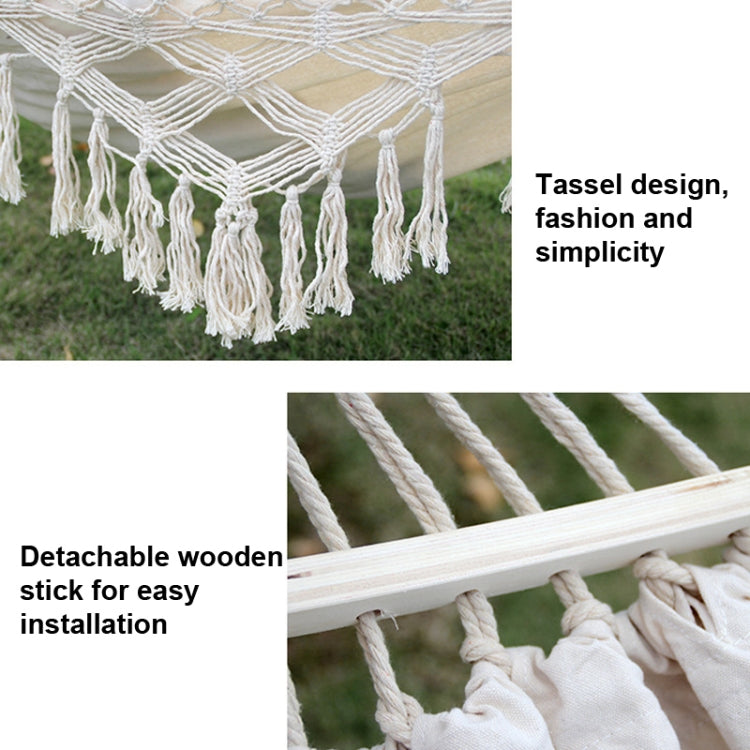 White hammock detail with macrame weave, cream tassel fringe, and braided hanging ropes.