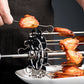 Electric rotisserie skewer grill with cooked lamb pieces on a tabletop frame