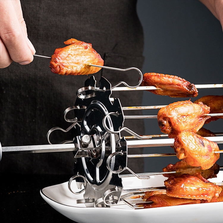 Electric rotisserie skewer grill with cooked lamb pieces on a tabletop frame