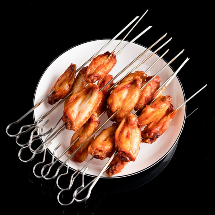 Cooked lamb skewers on a metal rod rack above a serving plate