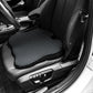 Black car seat cushion installed on vehicle seat, textured breathable mesh surface visible
