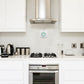 WiFi gas leak detector on wall, white unit with green alarm status ring