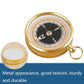 Gold metal outdoor compass with black dial, clear window, and keyring loop.