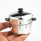 Hand holding stainless steel pressure cooker with domed lid and mechanical timer dial