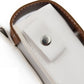 Close-up of light gray leather mini golf protective bag with brown edge trim and metal snap