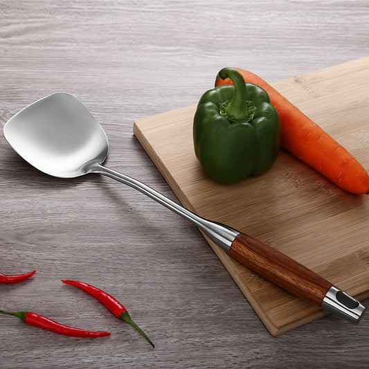 Stainless steel soup spoon with wooden handle, oval bowl and angled neck.