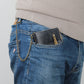 Black tri-fold zipper wallet clipped in jeans pocket with gold chain strap