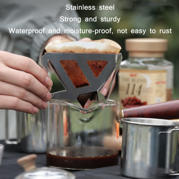 Stainless steel folding coffee filter funnel set on glass carafe with paper filter