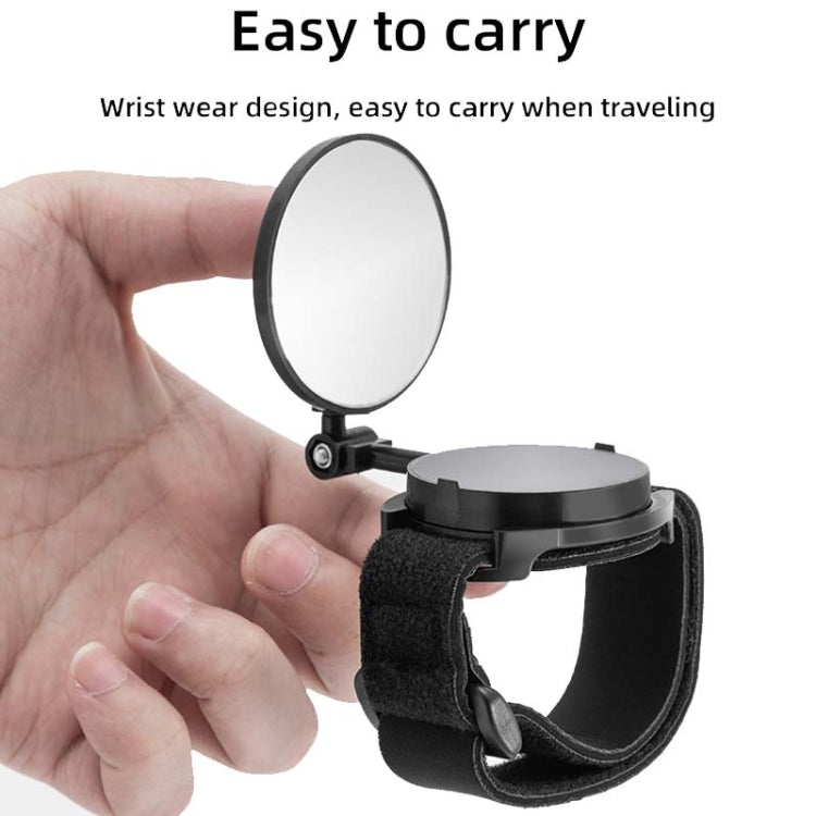 Bicycle rearview mirror with black wrist strap, held in hand for easy portability