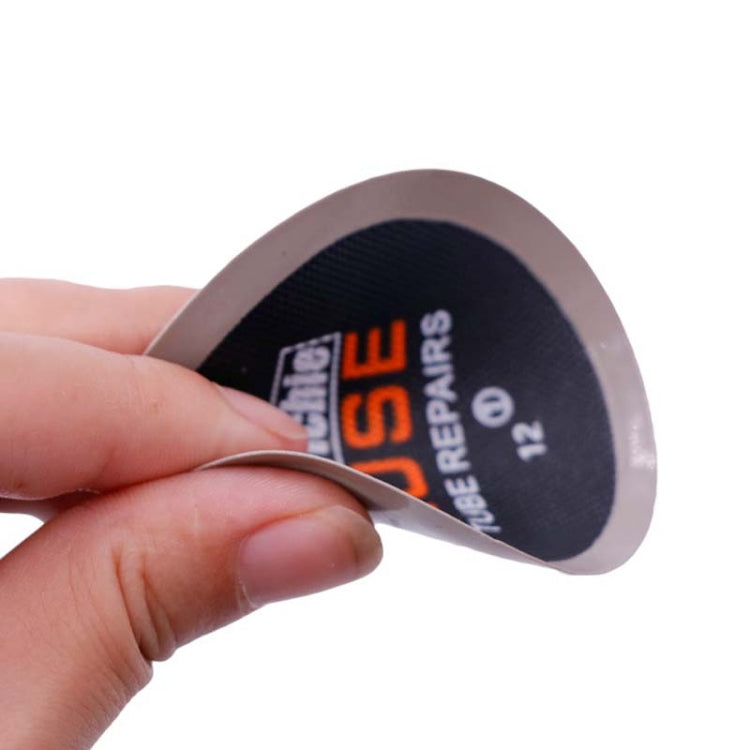 Hand holding a round tire repair patch disc, black label with 2-use