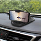 Black suction cup phone holder mounted on car dashboard holding a smartphone