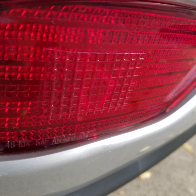 Red taillight lens surface with reflective grid texture for repair patch coverage