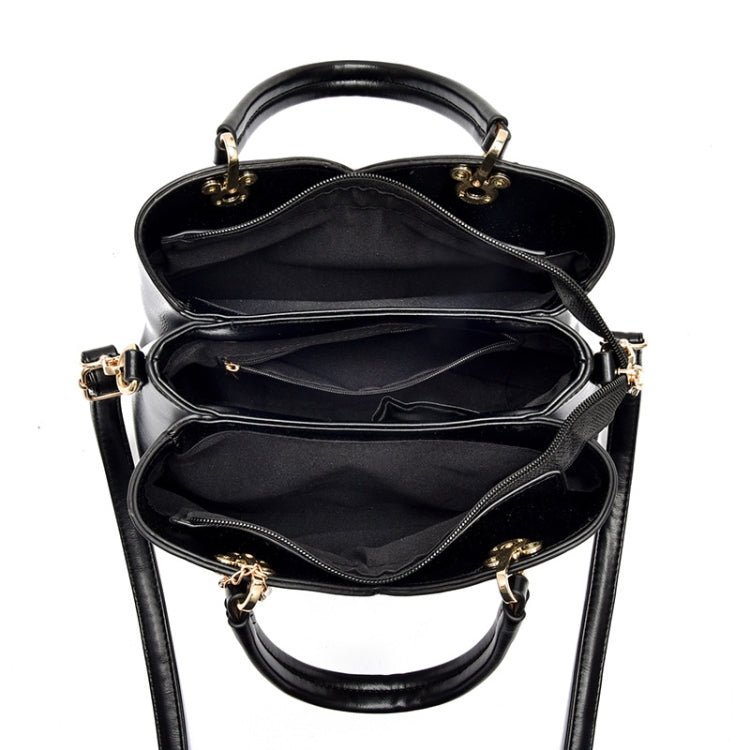 Open black handbag with two compartments, zip closure, and gold-tone hardware at handles