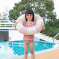 Inflatable underarm swimming ring with pink-and-white stripes, held around chest