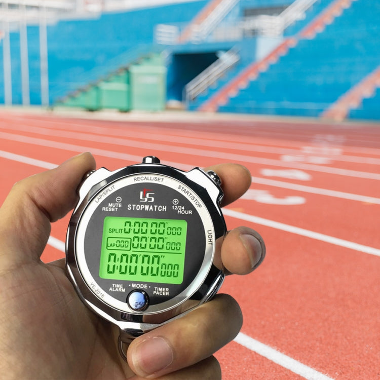 Hand holding metal luminous stopwatch on a running track with green LCD timer