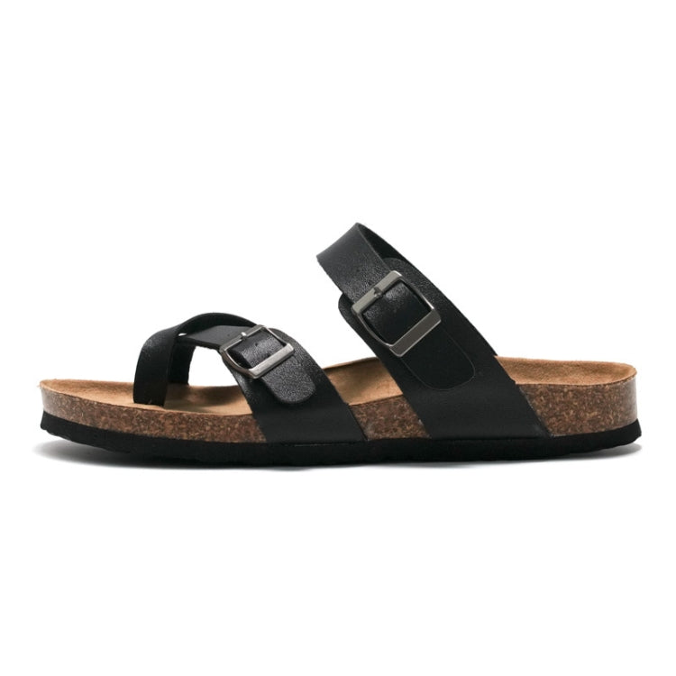 Black cork slide sandals with wide straps and metal buckles, side view