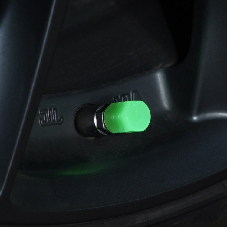 Green luminous tire valve cap fitted on a motorcycle wheel valve stem
