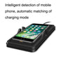 Black wireless charging pad holding a smartphone with charging indicator