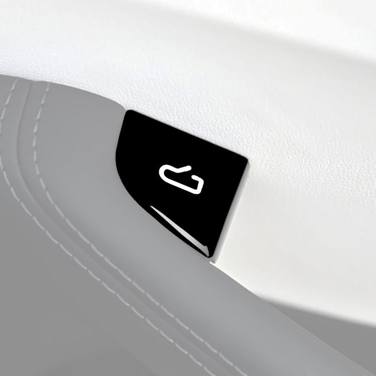 Black window switch sticker with white icon on a car door armrest