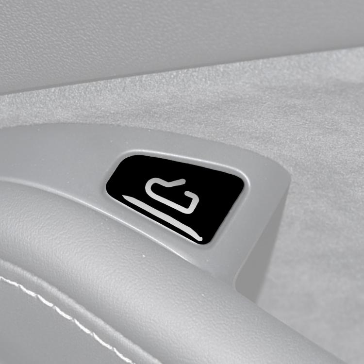 Close-up of car window switch sticker, black with white unlock icon
