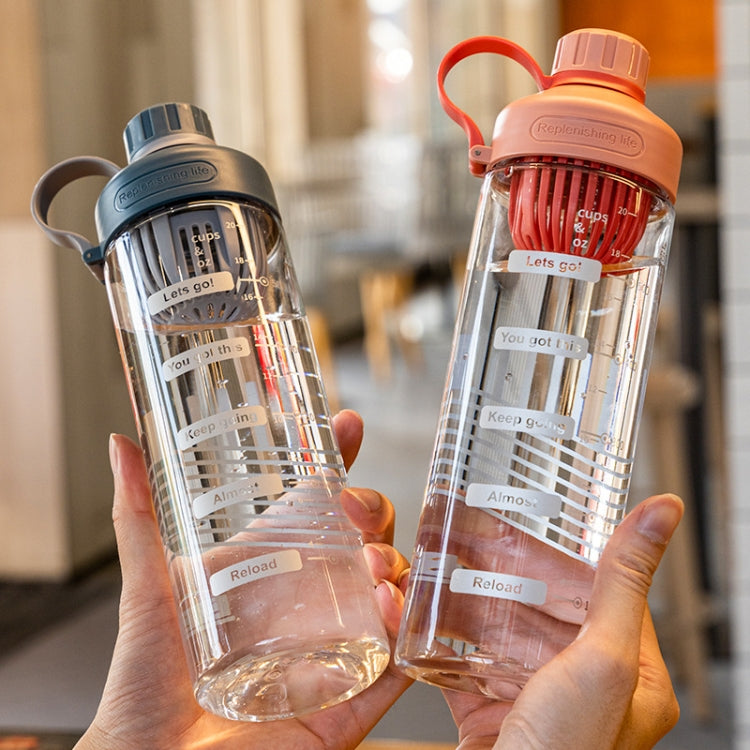 Pair of transparent portable tea cups with orange and gray lids held in hands