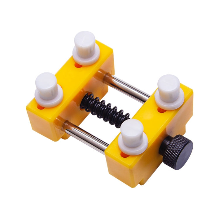 Yellow watch repair tool clamp with metal rods, spring, and white posts