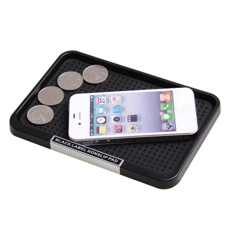 Black textured non-slip tray holding coins and a smartphone