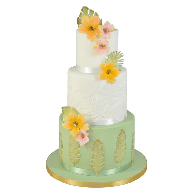 Tiered cake decorated with green tropical leaf fondant accents and flowers