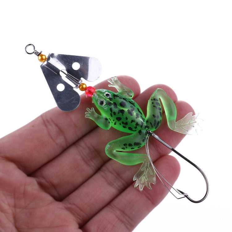 Soft frog fishing lure on a hand: green glitter body with spinner blade and hook