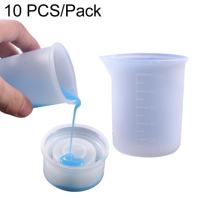Translucent 100ml silicone measuring cup with scale, pouring blue liquid into a smaller cup