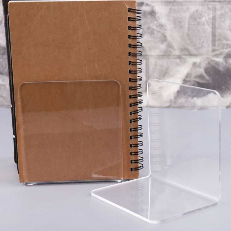 Brown notebook and clear acrylic L-shaped bookend set on bookshelf