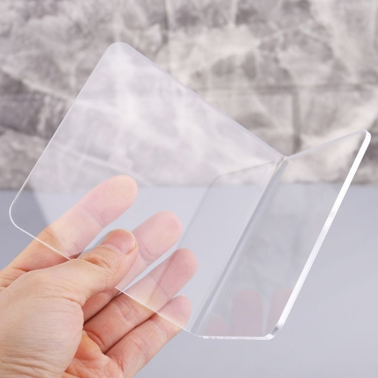 Clear acrylic L-shaped bookend, front panel held in hand