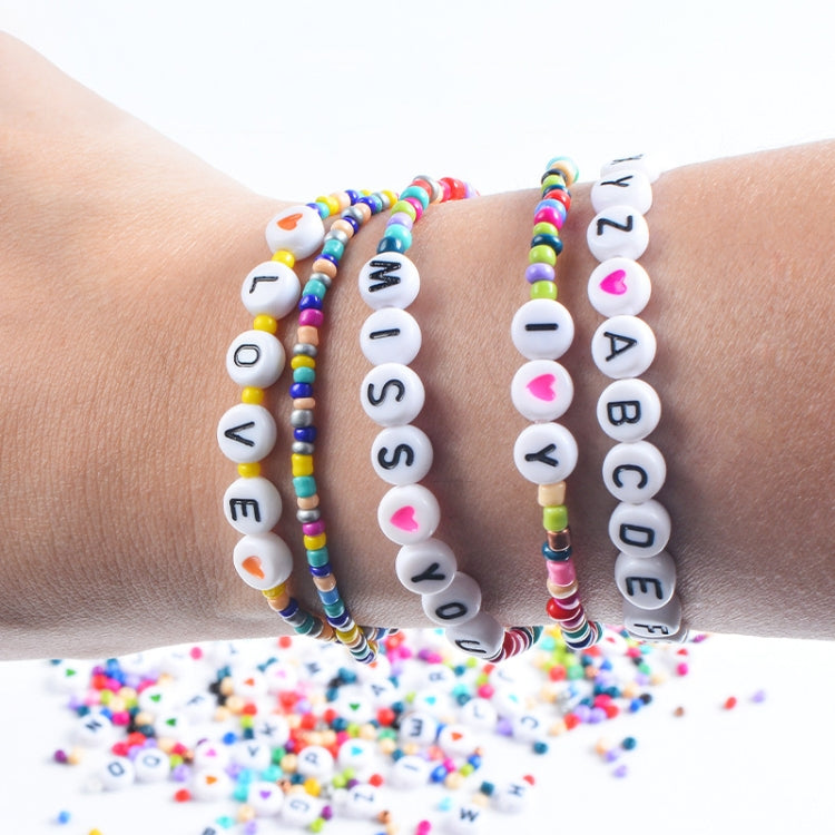 Beaded alphabet bracelets on wrist with white letter beads and colorful accents