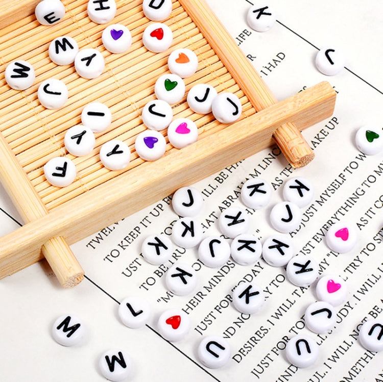 White alphabet letter beads with black letters on bamboo tray and paper cards