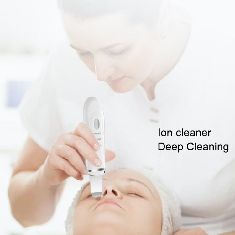 White handheld ion cleaner used on face with scraper tip above the nose