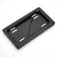 Black license plate bracket shell with four mounting slots and curved top