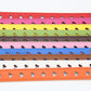 Close-up of heart cutout holes on a colorful pinching belt strap with stitching