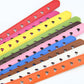 Colorful heart motif belt straps with silver eyelets and buckles, angled view