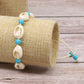 Beaded shell bracelet on braided rope with white cowrie shells and blue round beads