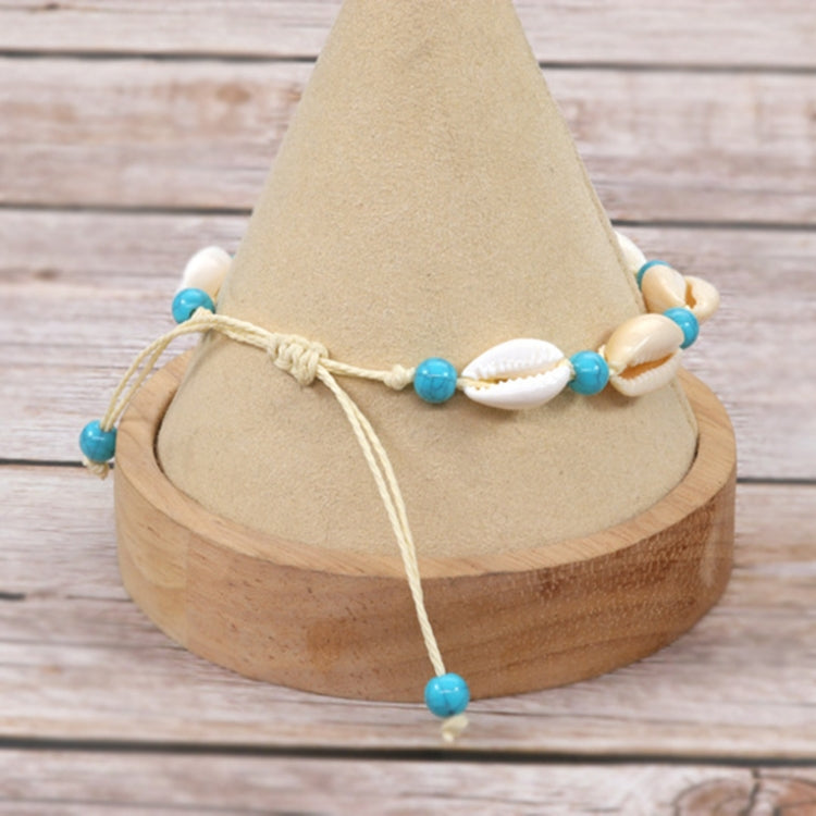 Adjustable rope shell bracelet with white cowrie shells and turquoise blue bead accents