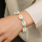 Shell bracelet worn on wrist with braided rope, white cowrie shells, and turquoise beads