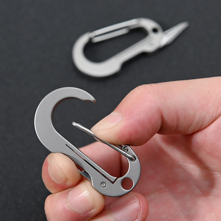 Silver keychain knife held in hand with extended blade and locking pin