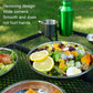 Stainless steel dinner plates with food served outdoors on grill mat