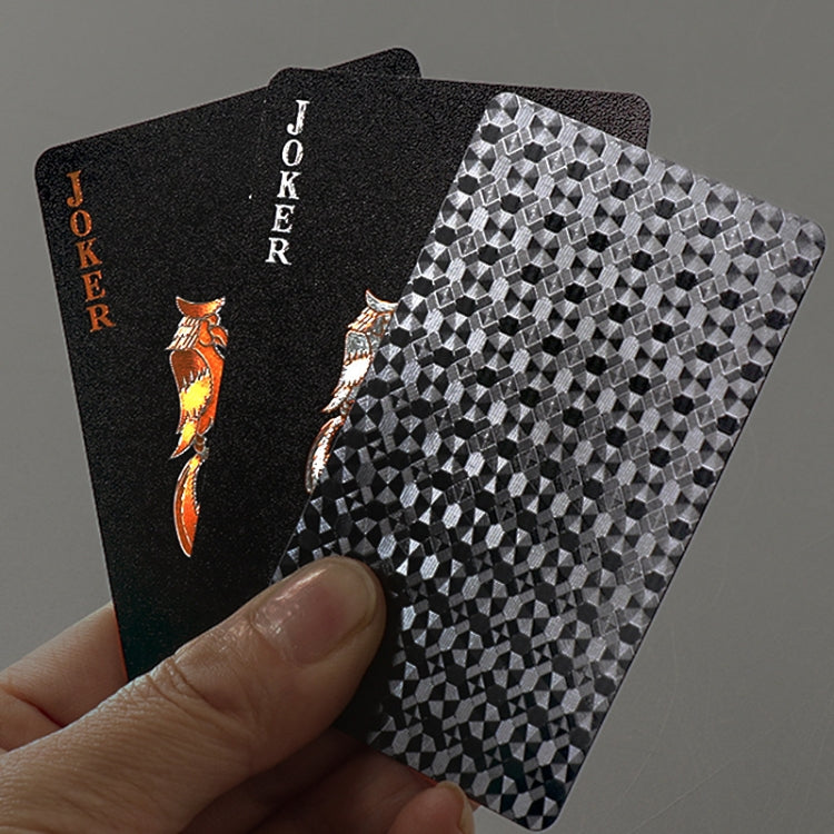 Two black playing cards held by hand, with gold JOKER and geometric back pattern