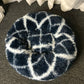 Round pet bed in dark blue with long shag fur and bold white geometric pattern
