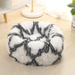 White round plush pet bed with long shag fur and black abstract pattern