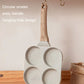 Four-hole omelet pan with hanging hole and wooden handle; speckled nonstick wells