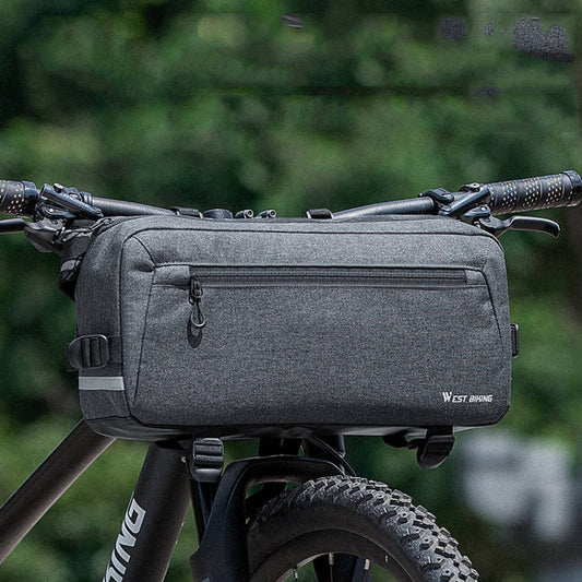 Gray bike handlebar bag with zip front and side straps, mounted on a handlebar.