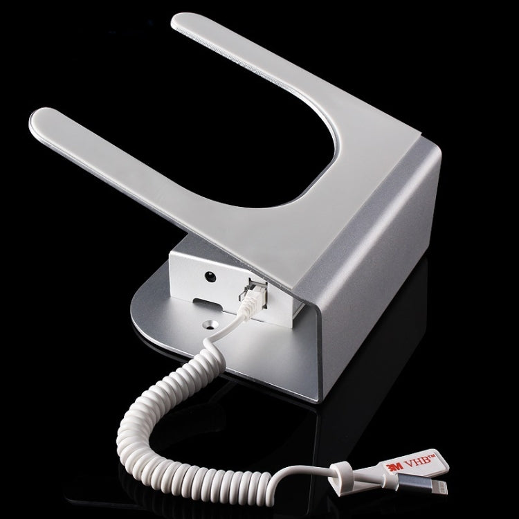 Silver anti-theft tablet stand with exposed port and white charging cable