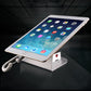 Anti-theft tablet display stand holding a tablet with charging cable